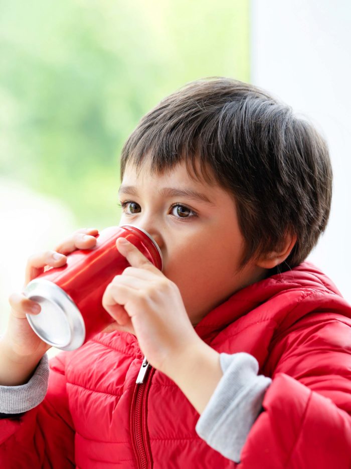 boy drinking soda from an aluminum can