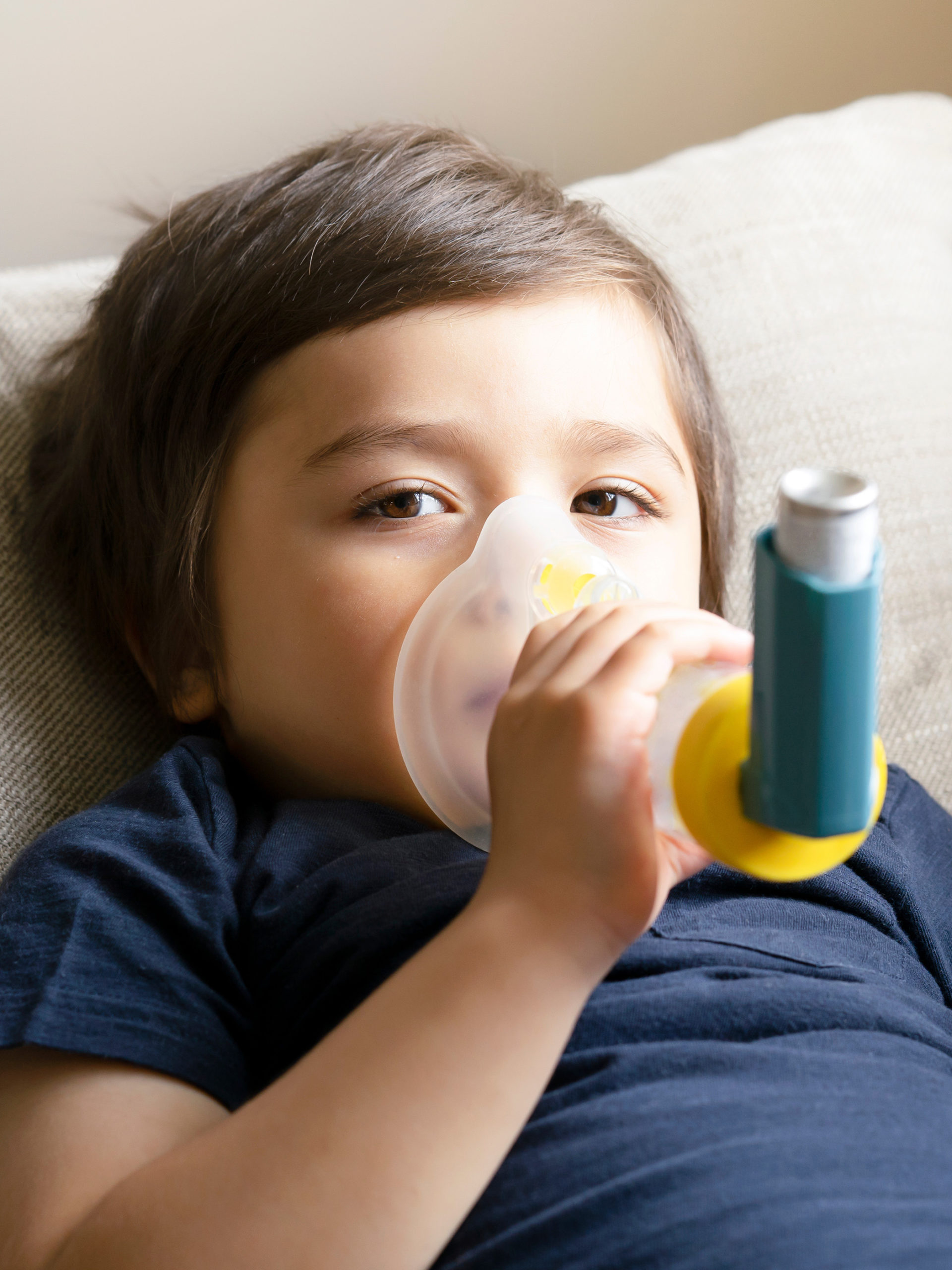 young boy having asthma attack using an asthma inhaler
