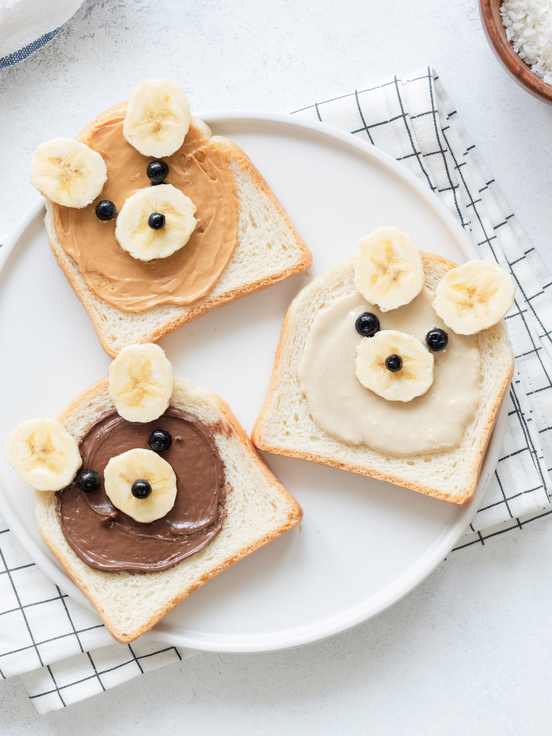 Breakfast toasts with nut butter and banana made to look like a cute bear face