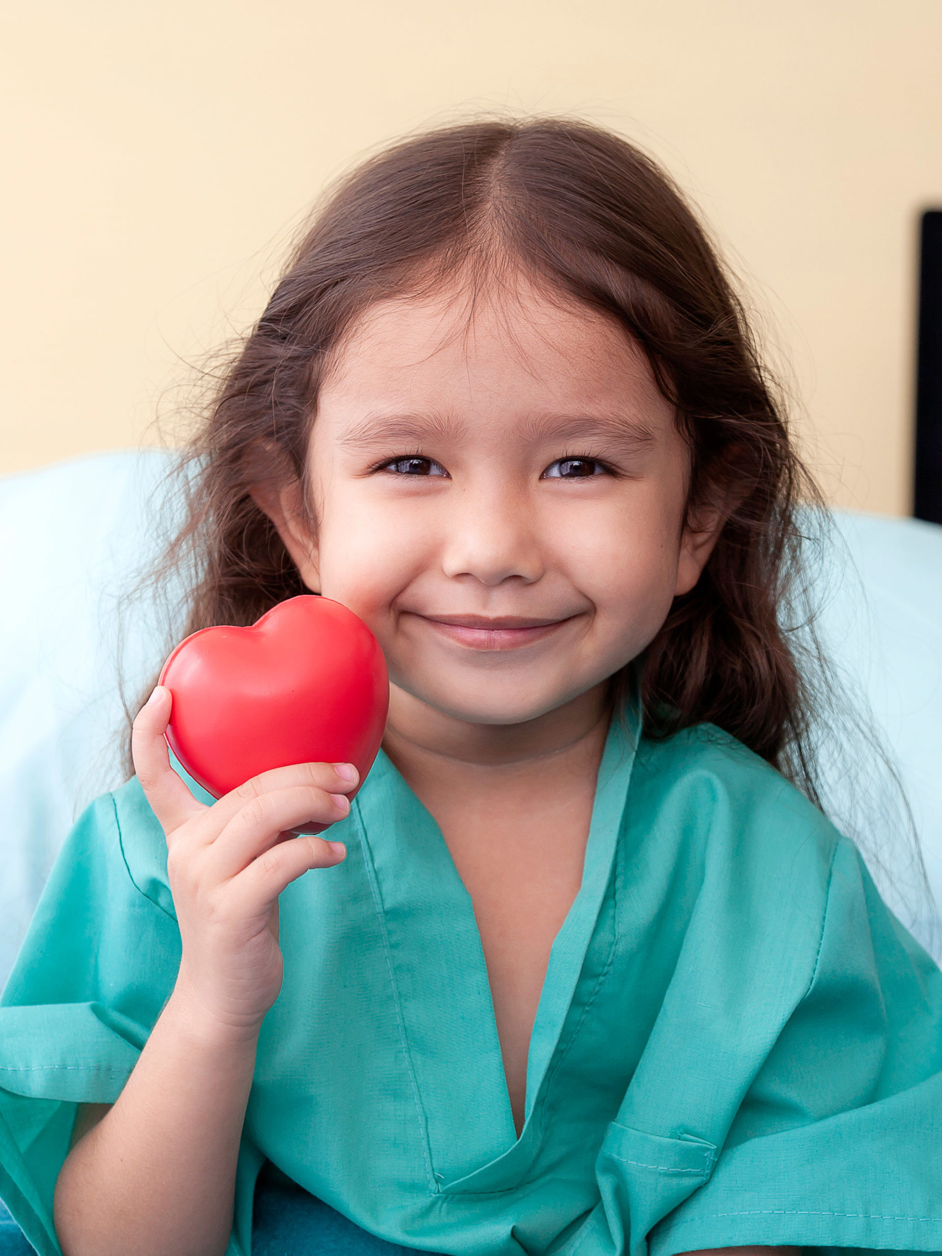 girl in hospital holding heart-shaped stress ball