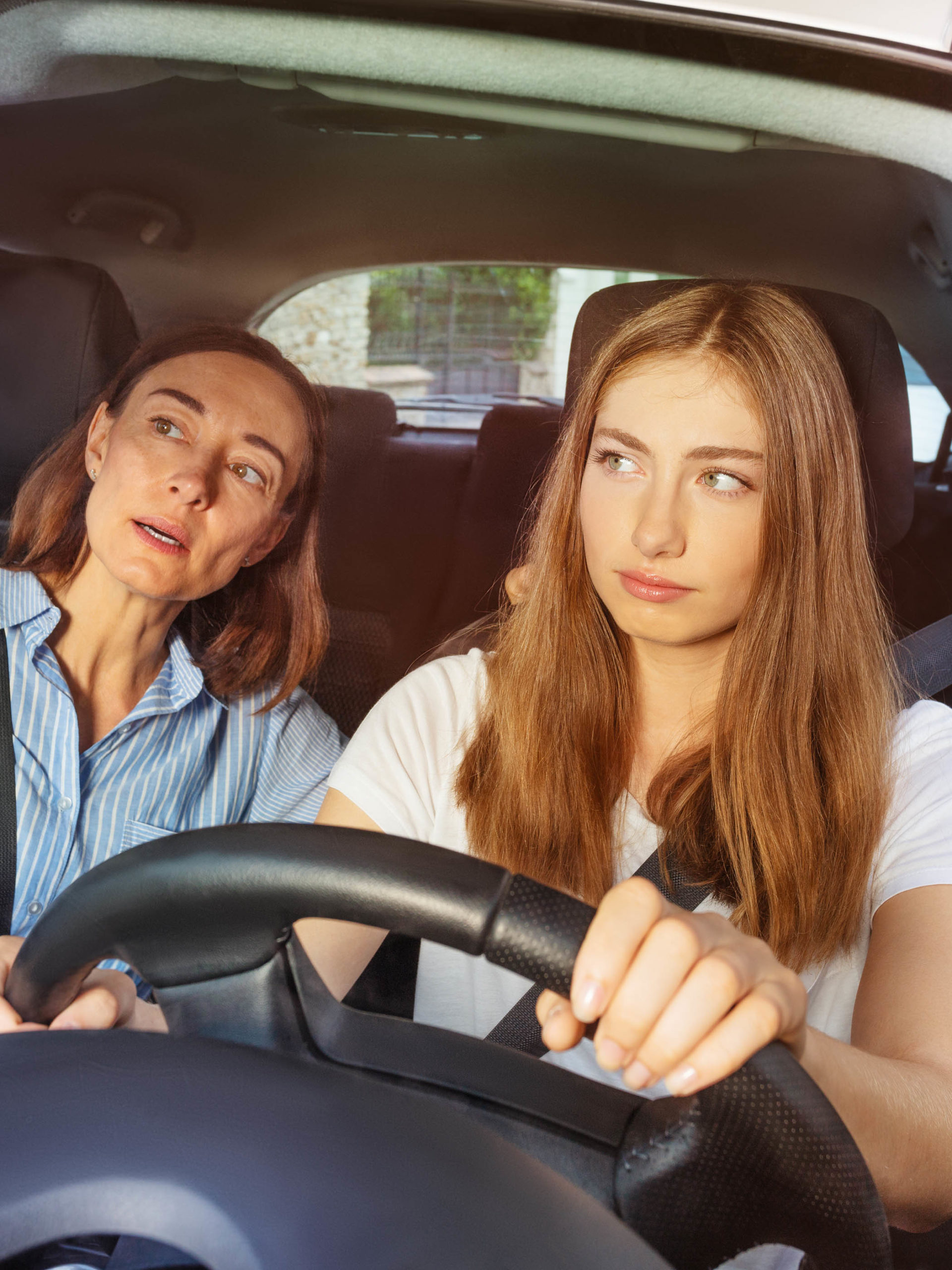 Girl and her mother during driving lesson in a car