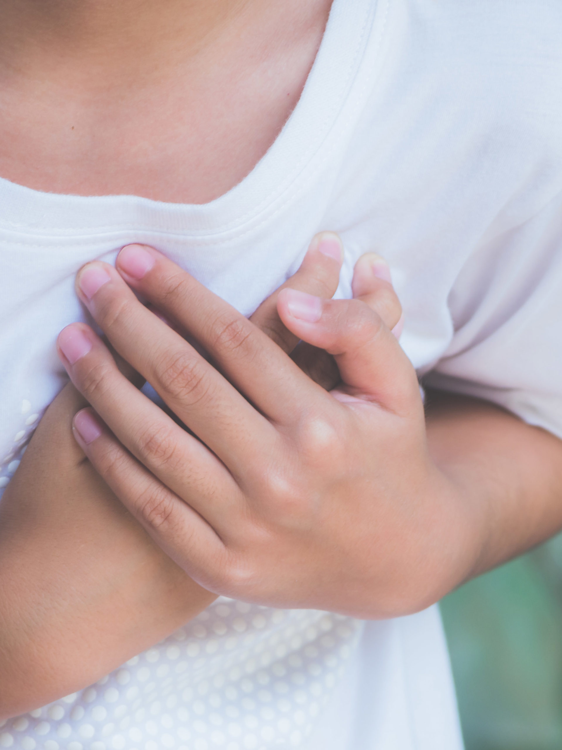 boy with chest pain holding his hands to his heart
