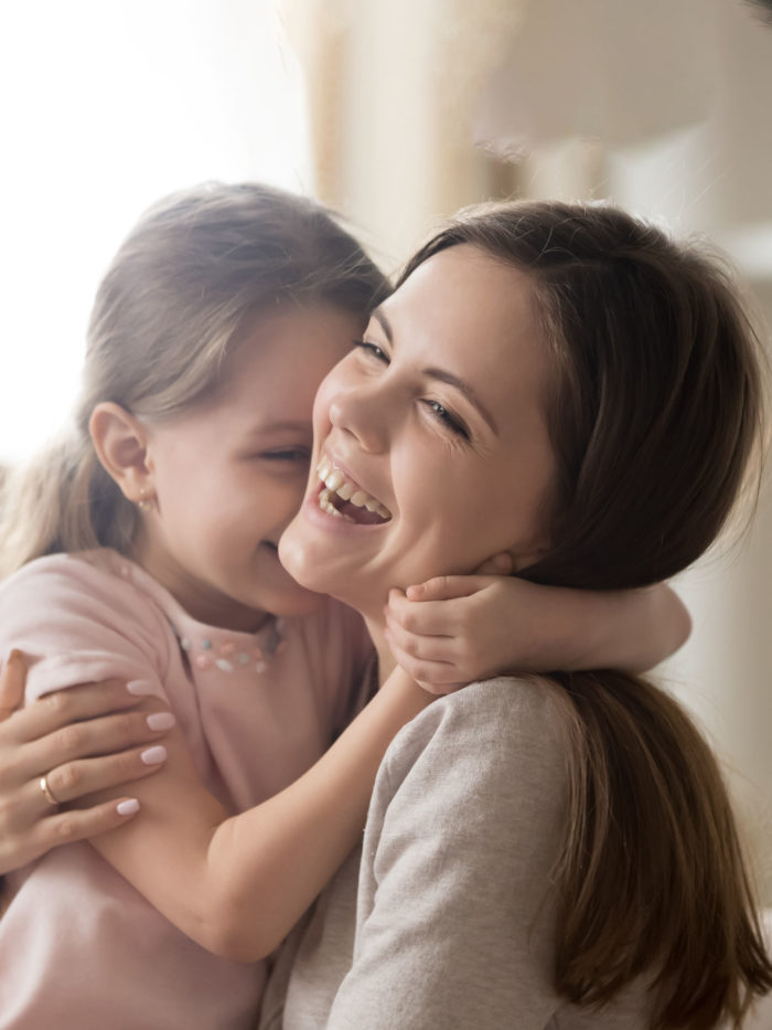 mom with little girl hugging and having fun playing