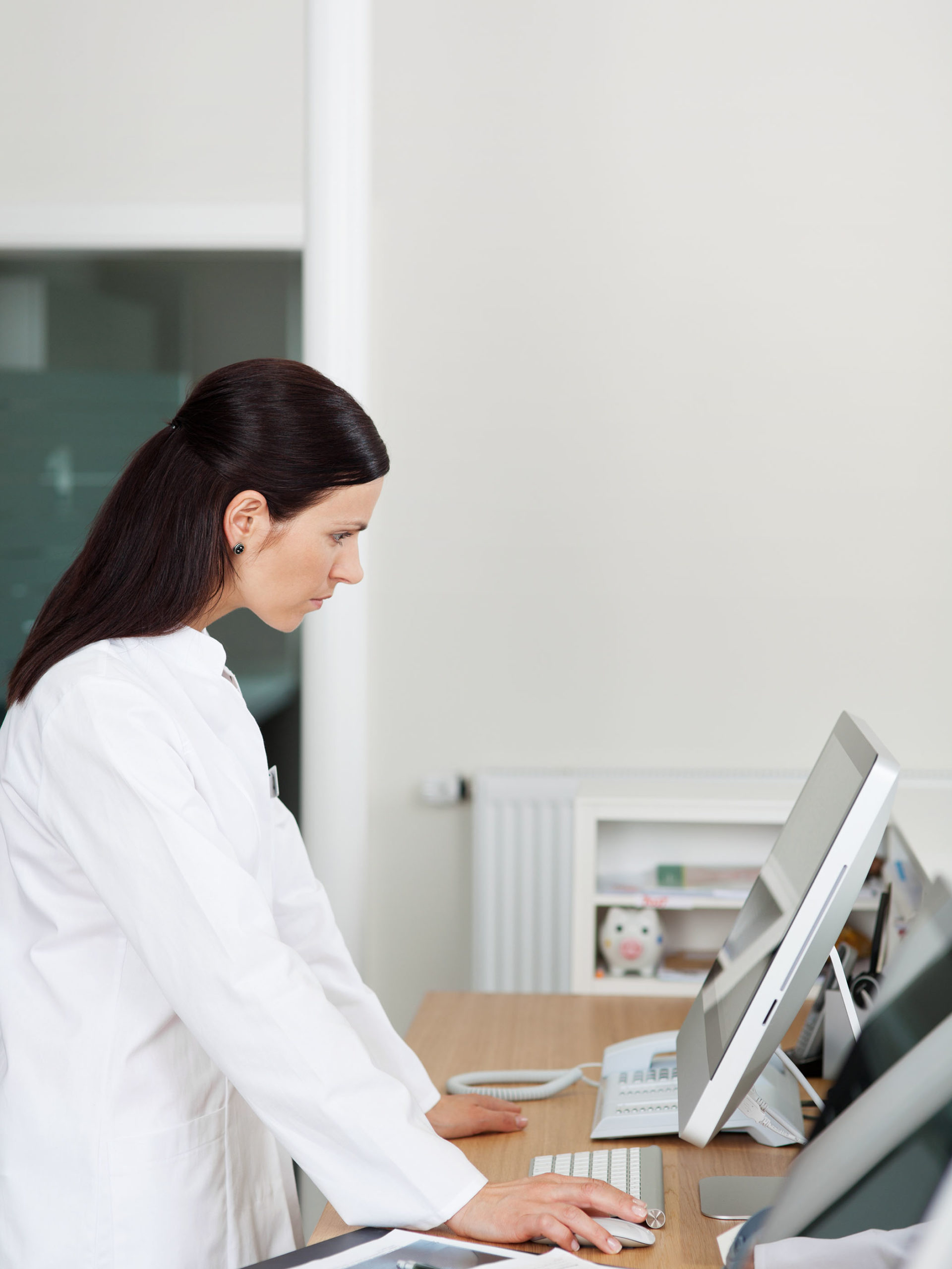 Female doctor looks at patient chart on computer