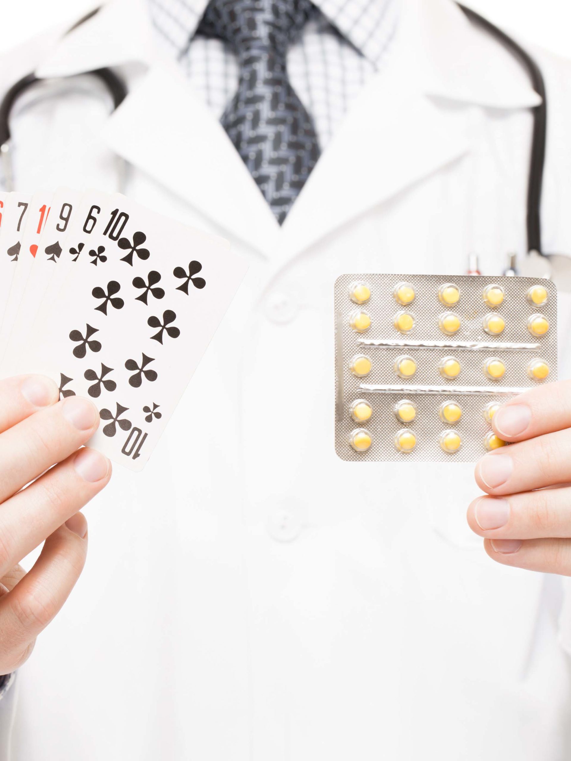 Dr. holding cards for magic trick in one hand and medication in the other