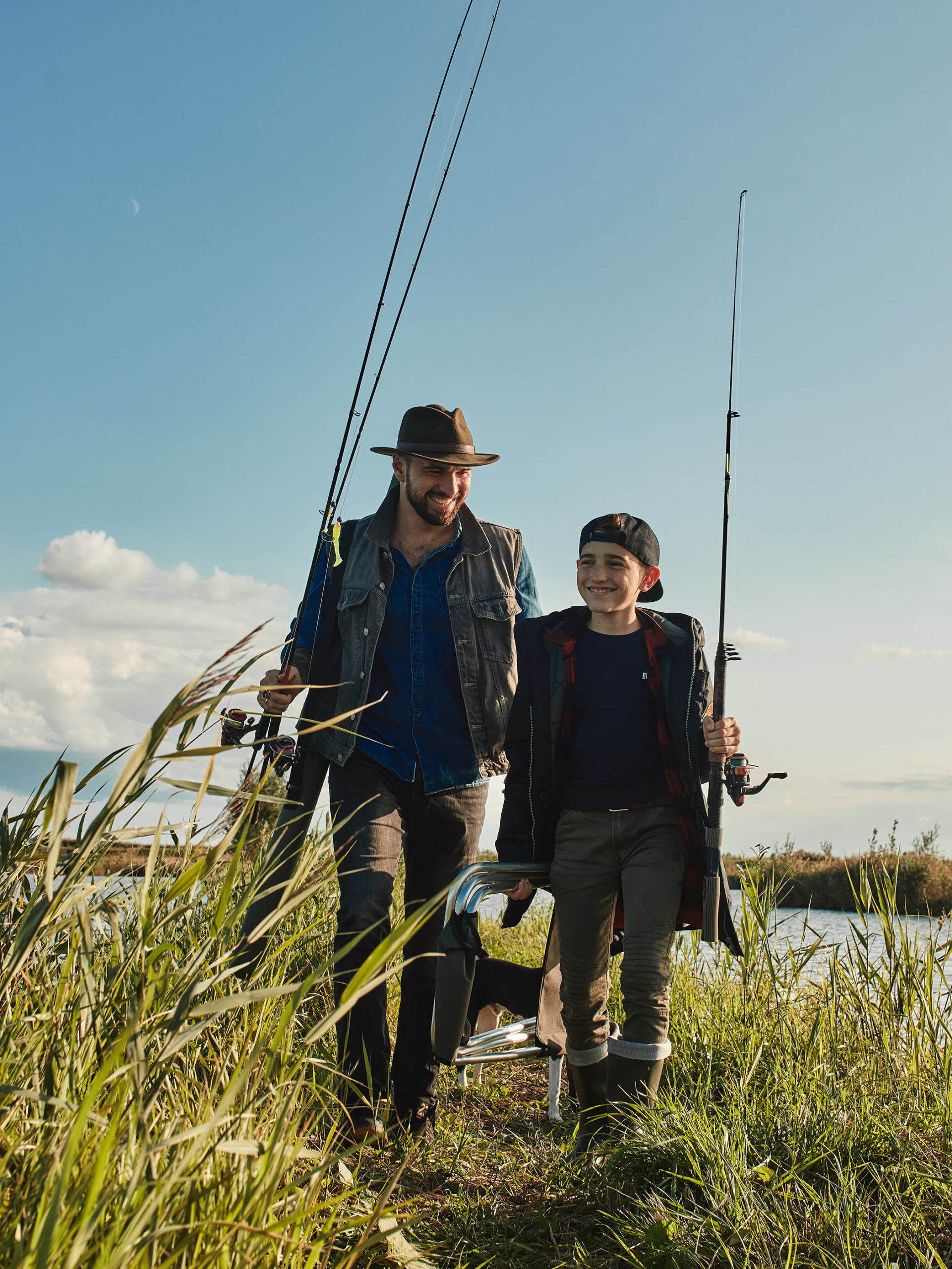 father and teen look for suitable place for fishing together