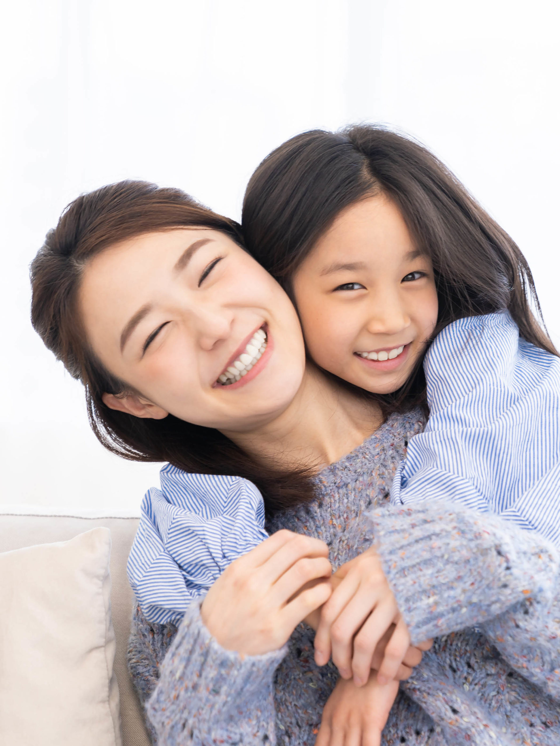 young mother and daughter smiling and hugging