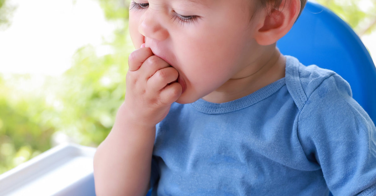 boy eating fruit and veggies by himself on high chair