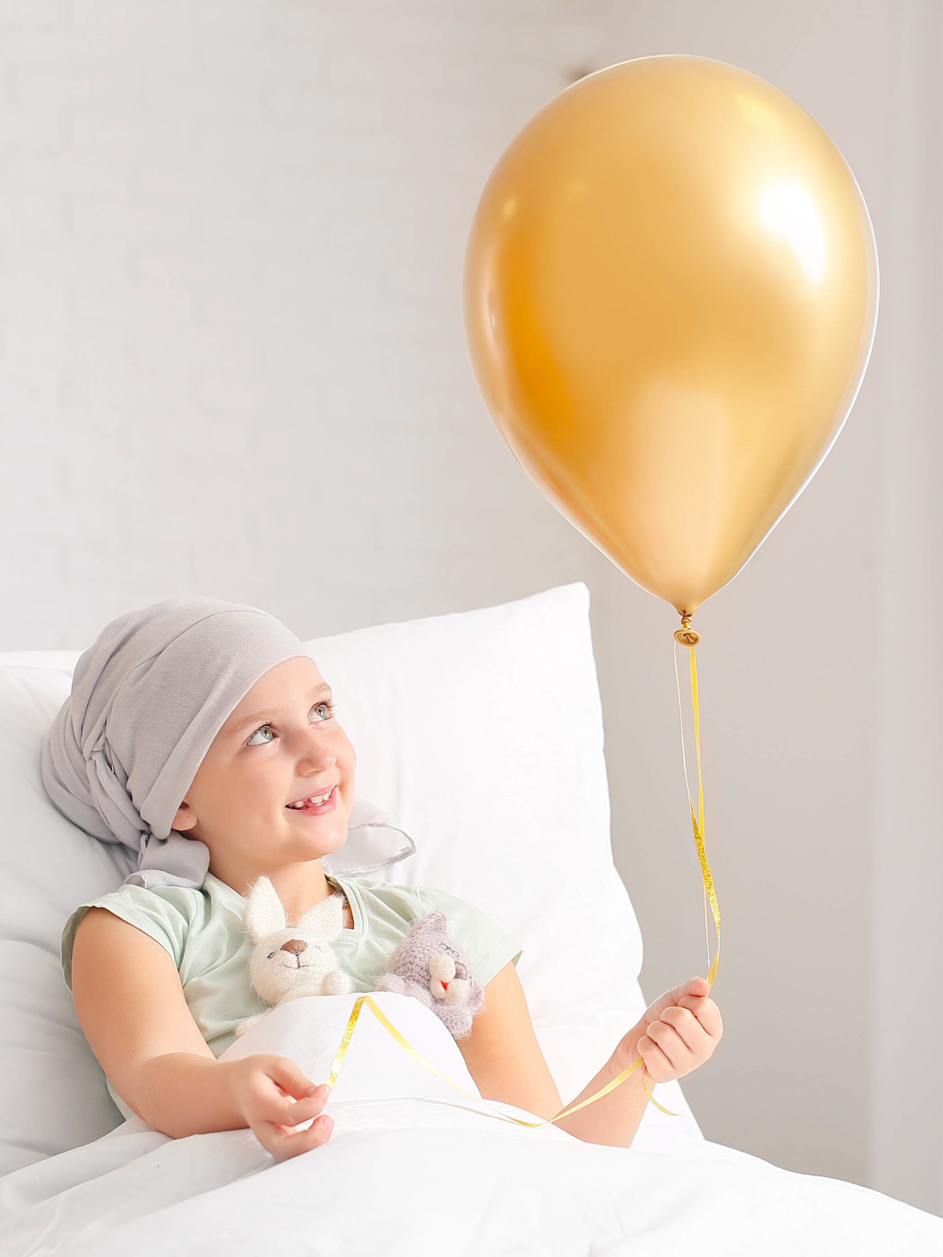 Little girl with golden balloon undergoing course of chemotherapy