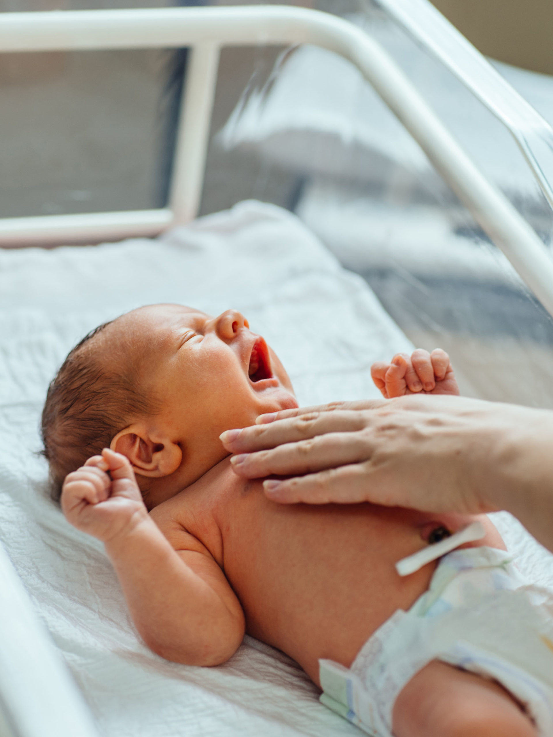 Yawning newborn baby infant in the hospital nursery