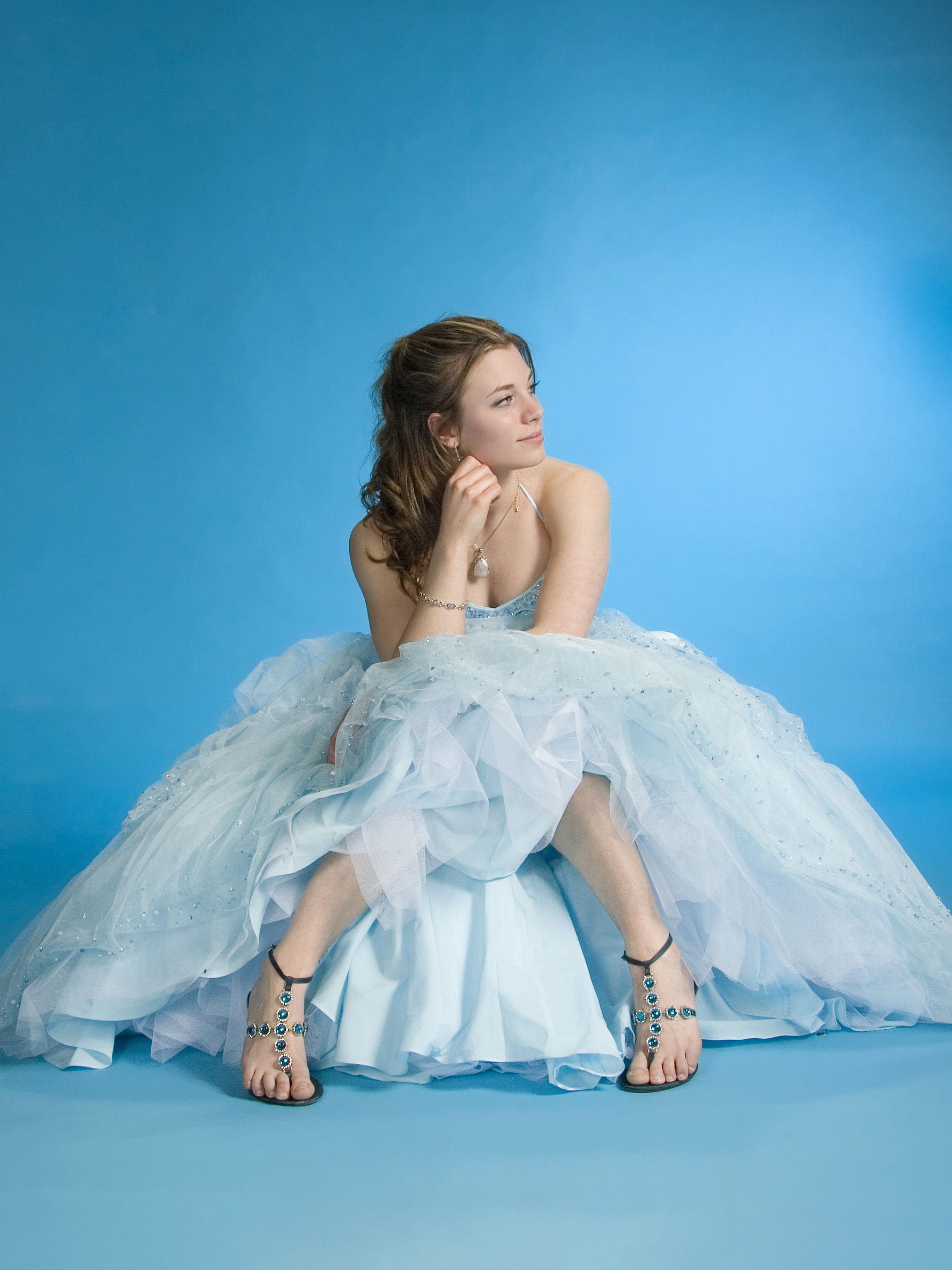 teenage girl wearing prom dress sitting for a portrait