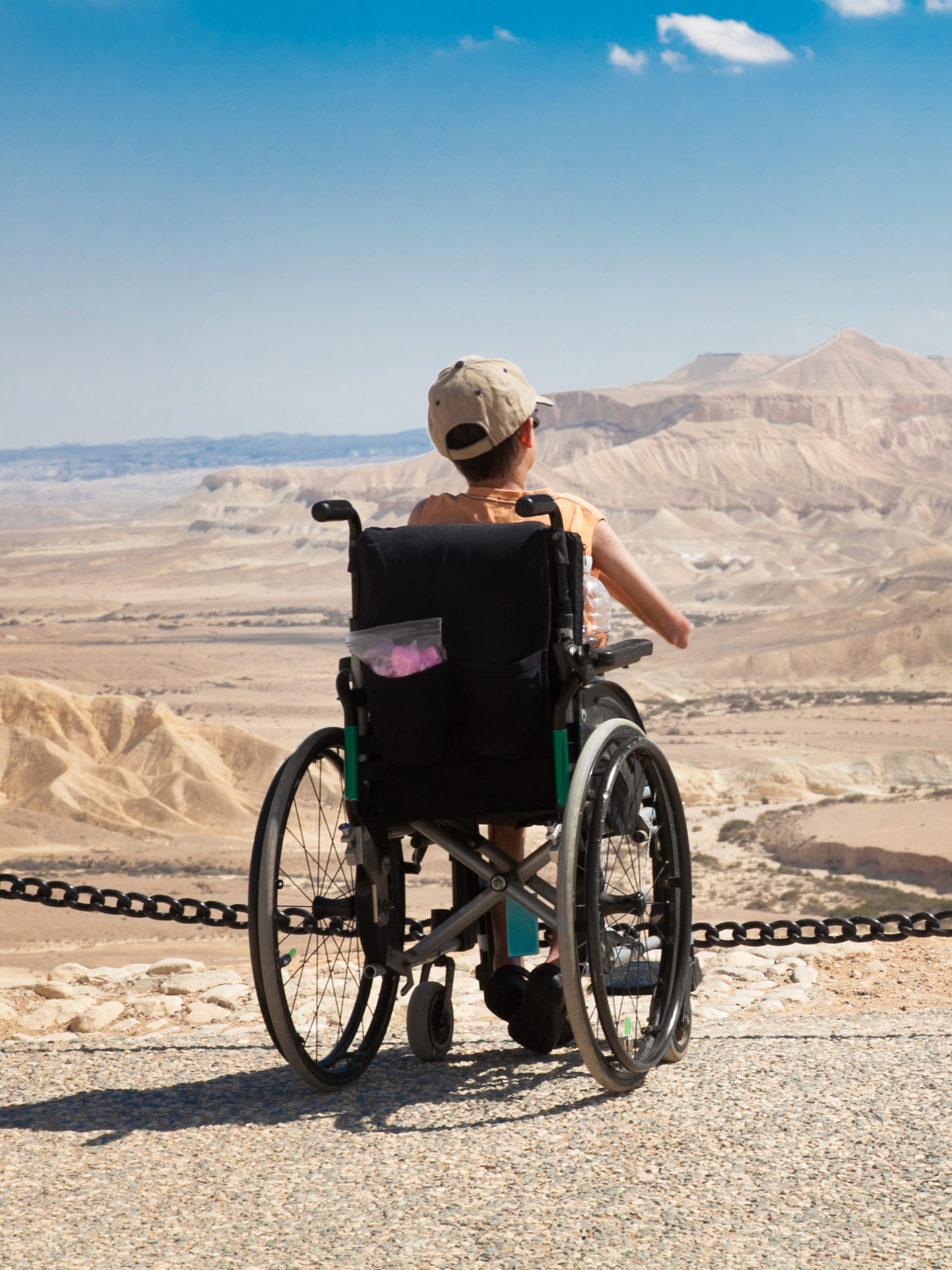 Young boy in wheelchair looking out at vista of desert