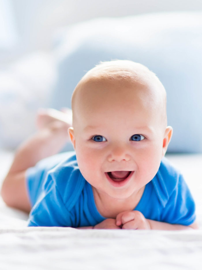 New born kid during tummy time on bed