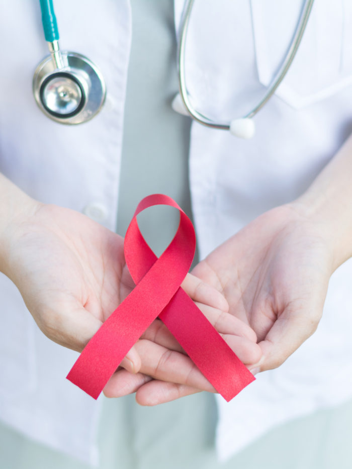 closeup of female doctor holding red ribbon for American heart month