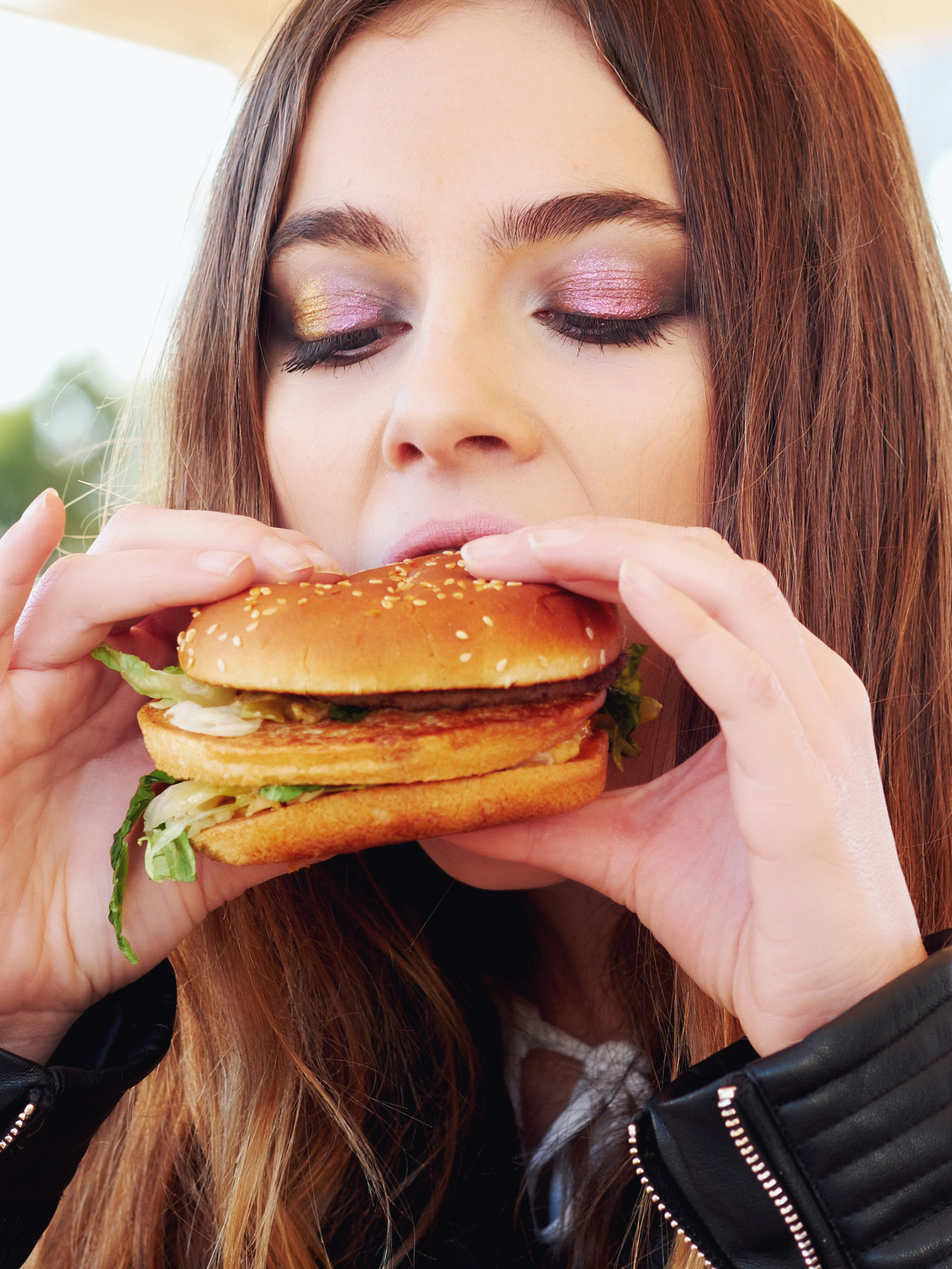 portrait for teenage girl eating a hamburger