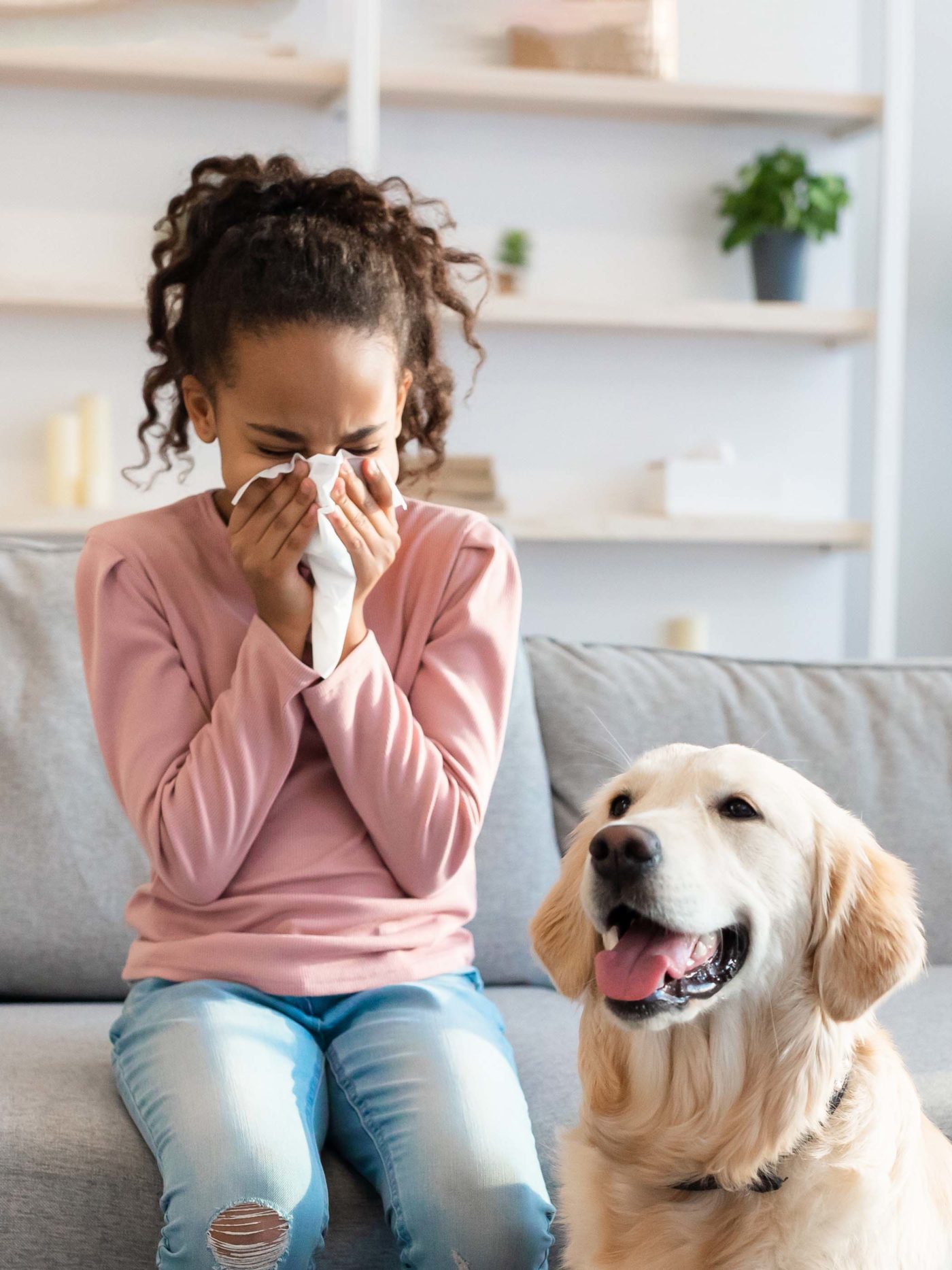 girl sneezes while sitting with pet dog