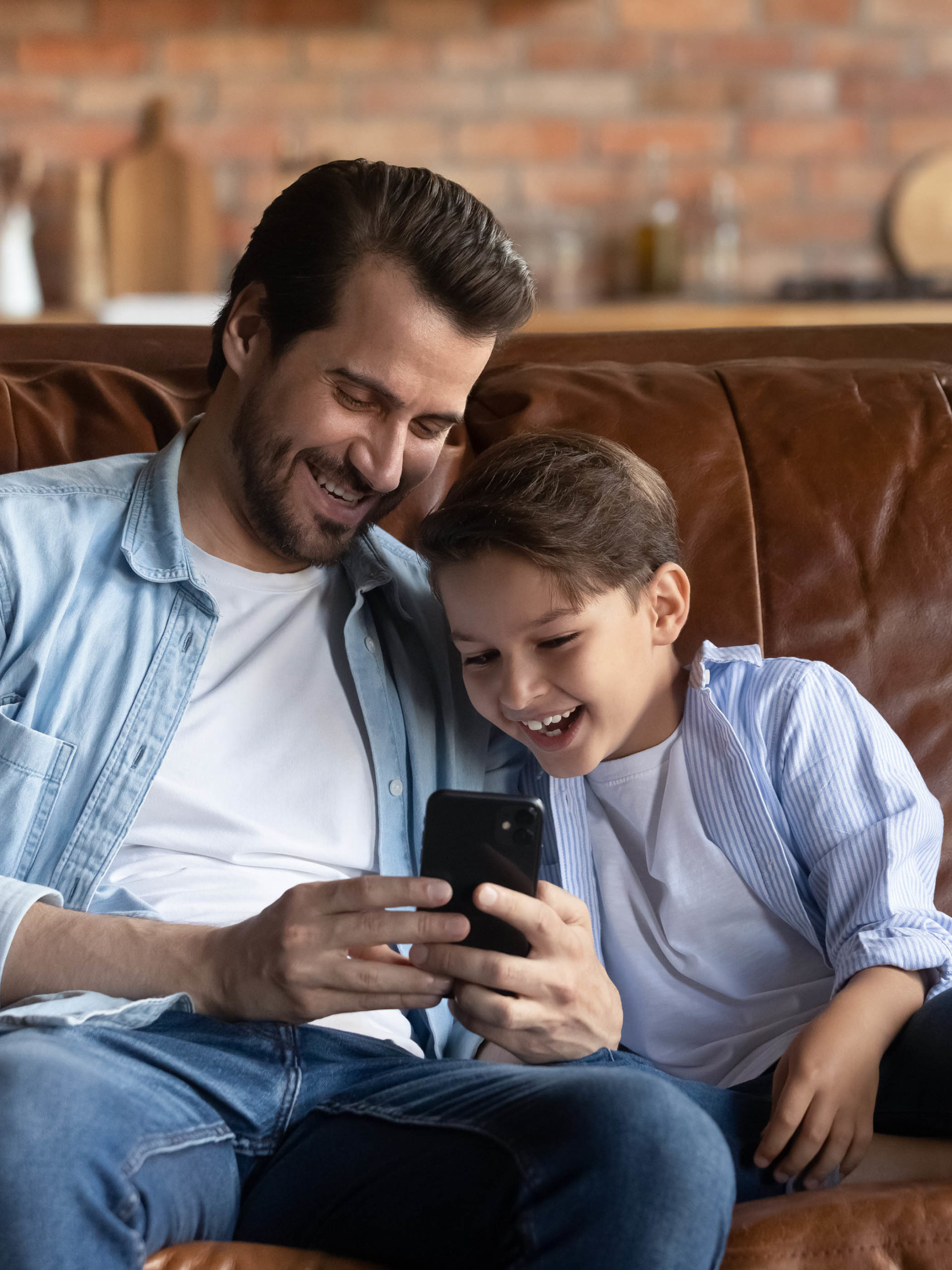 father and son watching funny videos together on smartphone