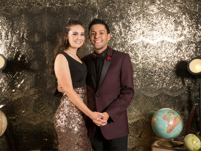 Lauren and Nick pose in front of a gold background at CHOC's oncology patient ball in 2018