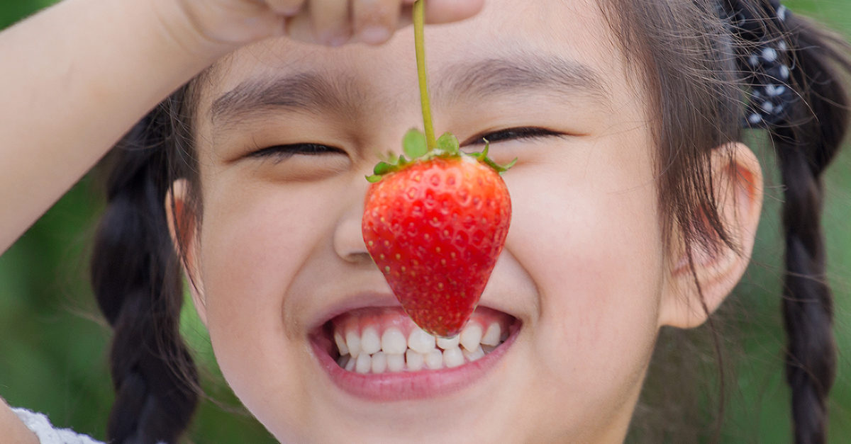 girl holding strawberry