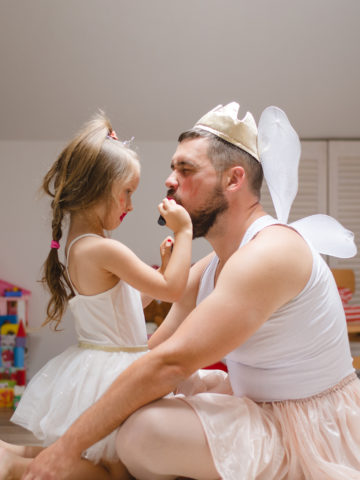 girl plays dress up with her dad