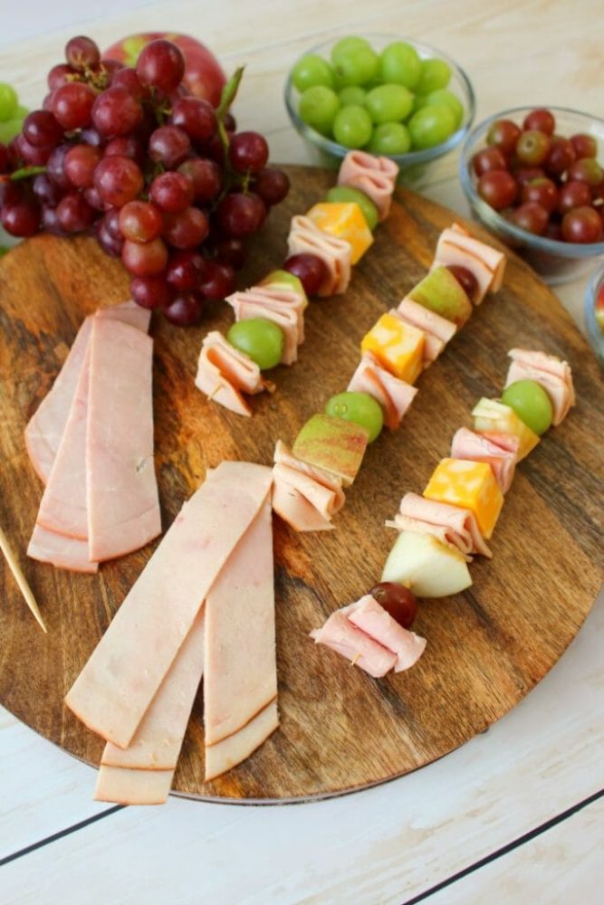 Turkey and ham skewers on a wooden cutting board 