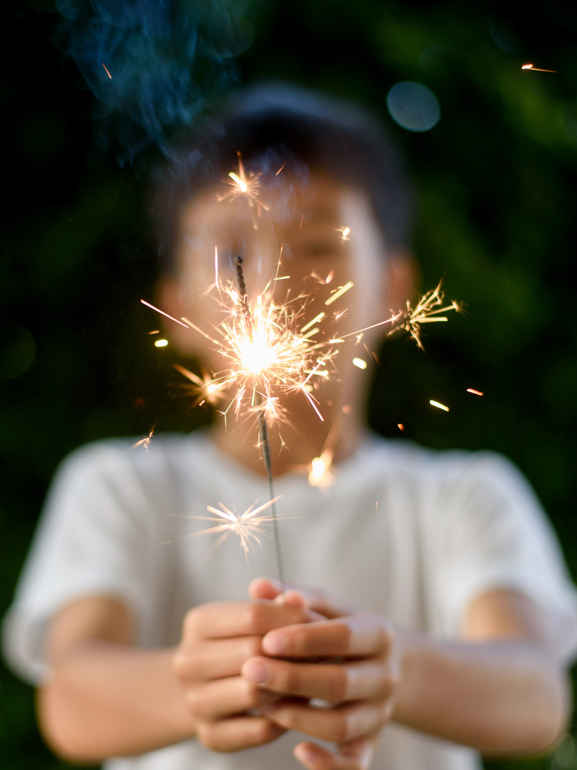 young boy holds sparkler