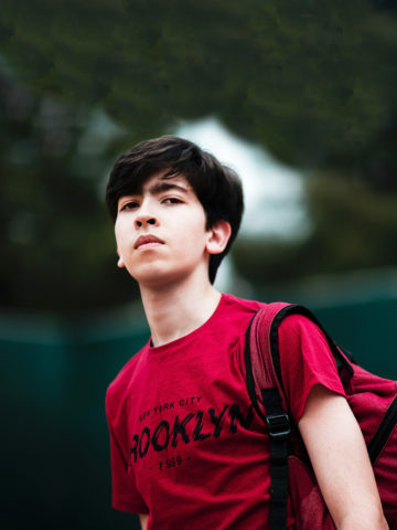 teen boy with backpack looking serious