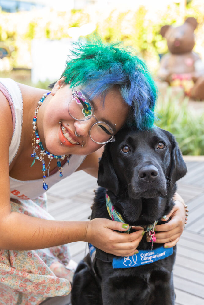 Joy smiles with black resident therapy dog, Odessa