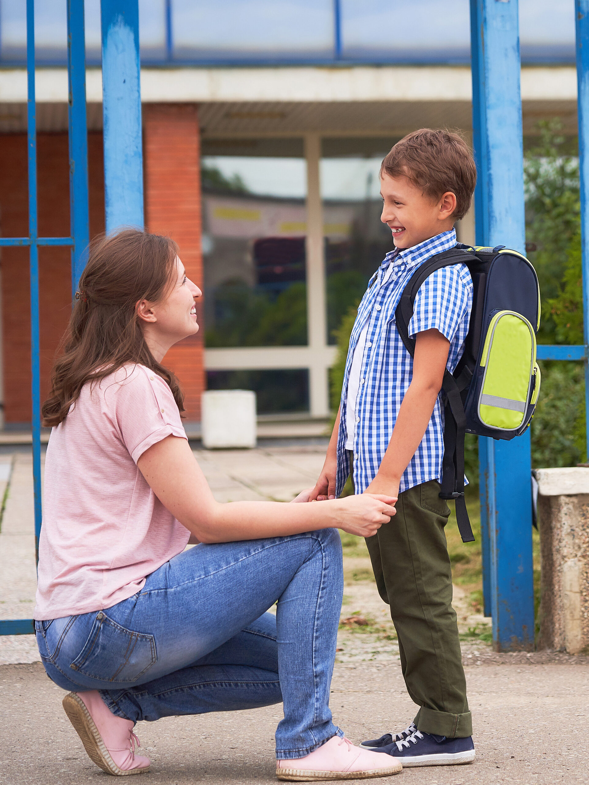mom looks at son with backpack on before going to school