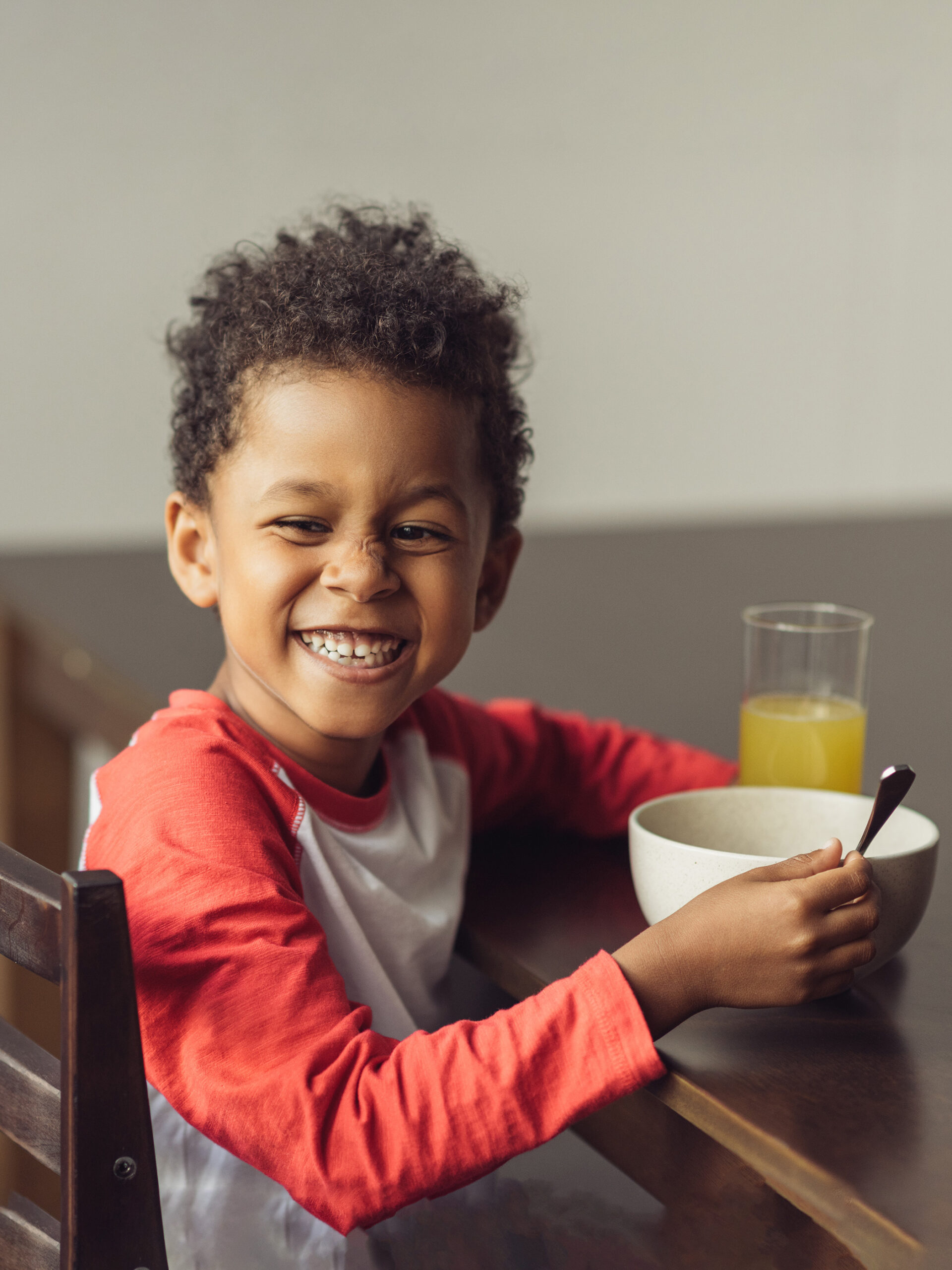 Boy smiles while eating breakfast
