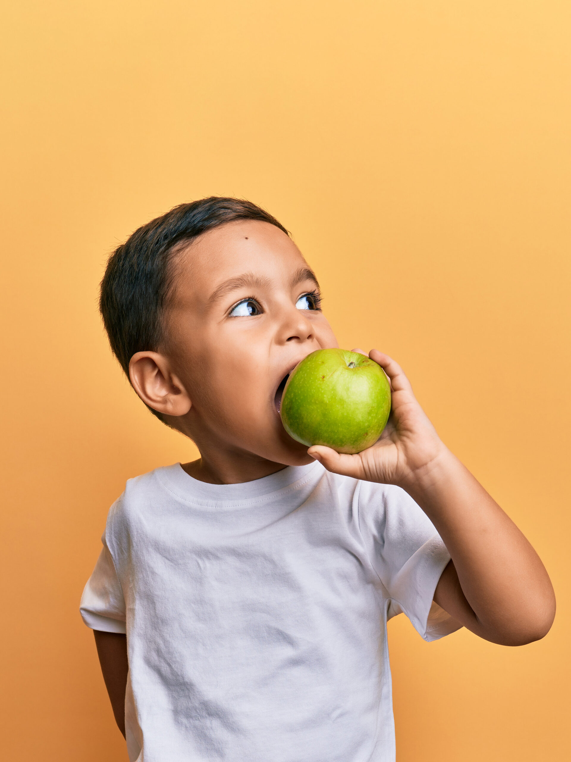 Little boy eats apple
