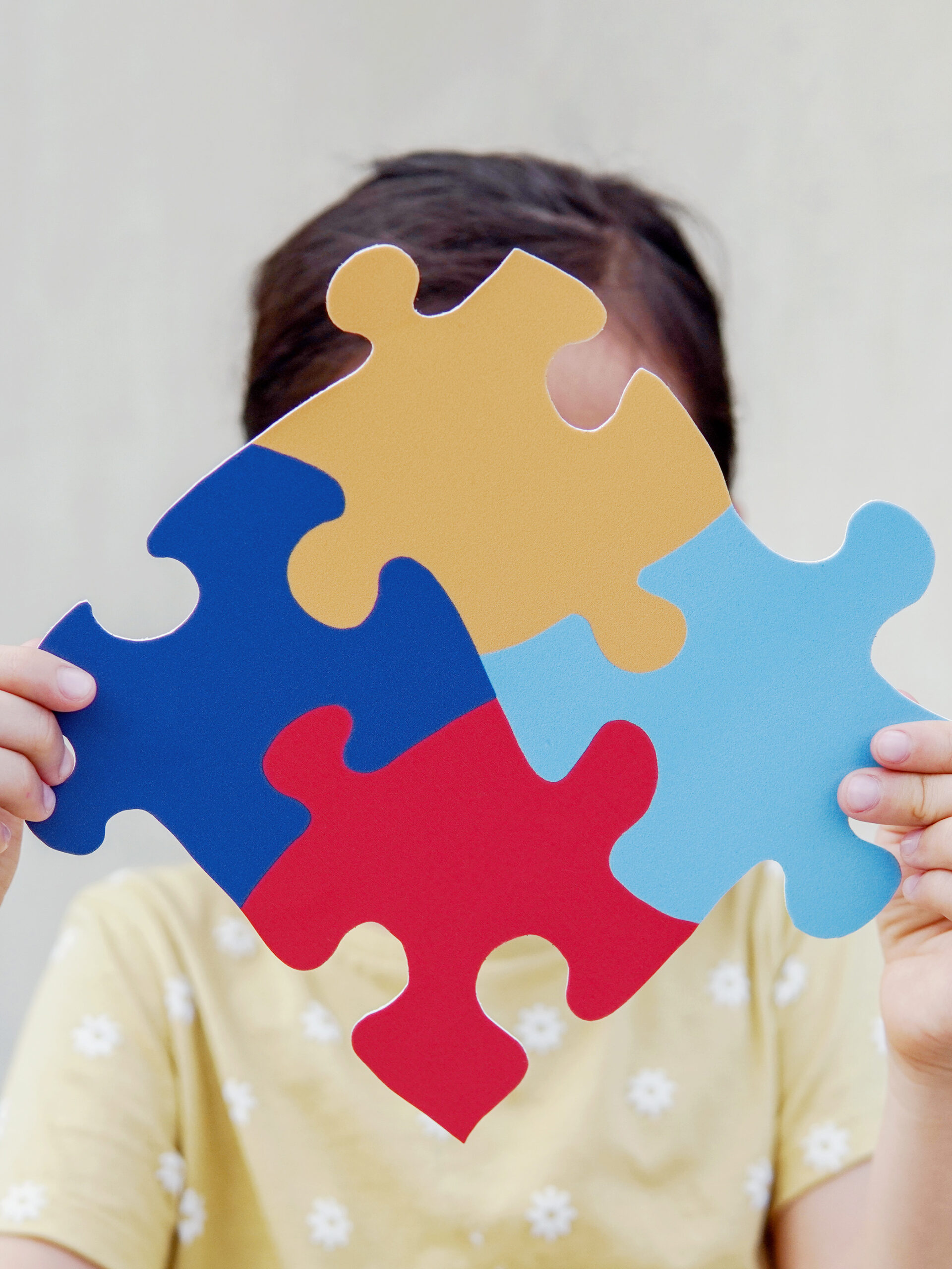 Child holds autism awareness puzzle pieces