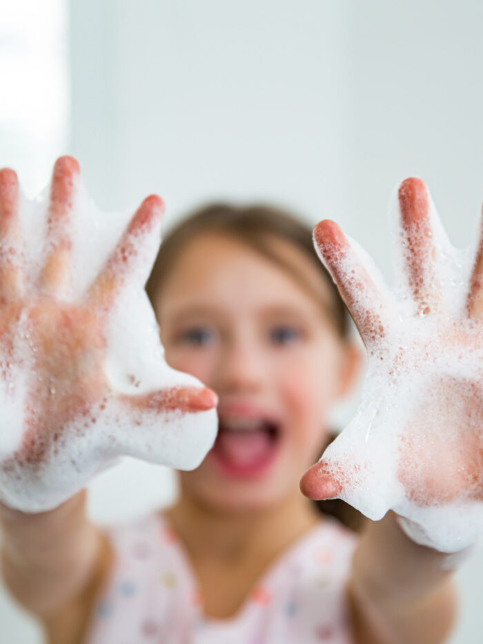 Child washes hands to prevent spreading germs
