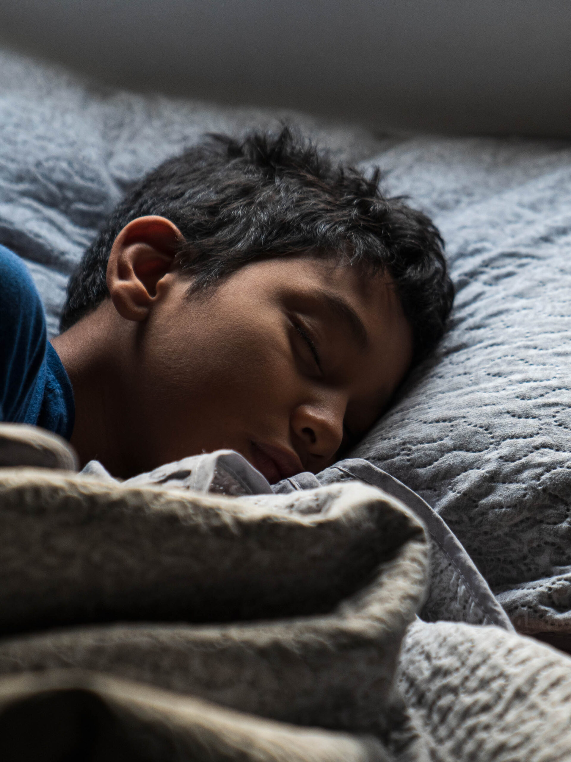 A Hispanic Young Sick Boy is Sleeping on His Bed with His Head on The Pillow Early in The Morning at His House. Copy Space