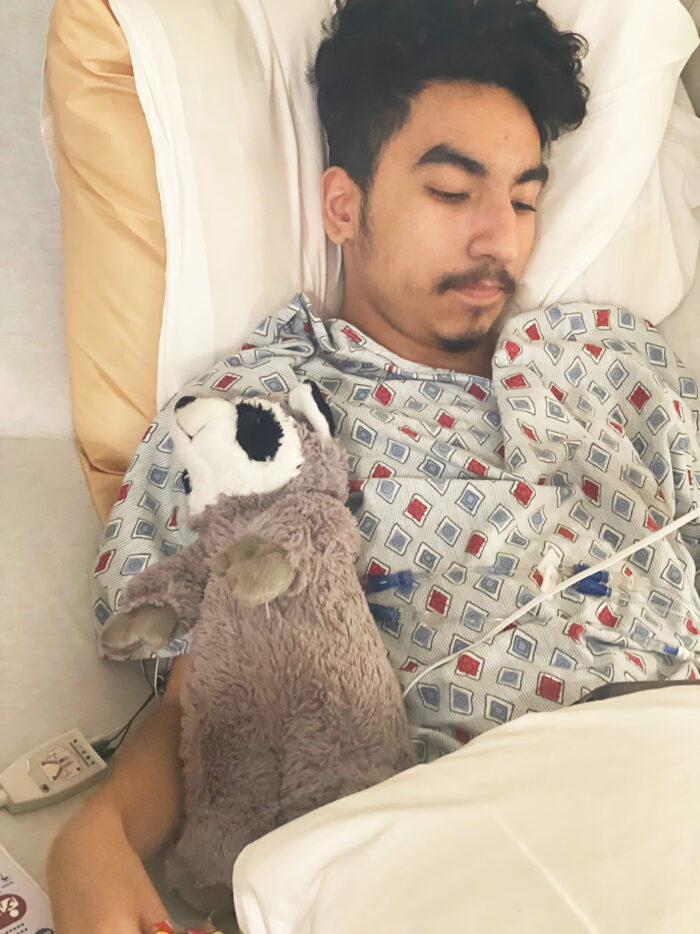 Hector with stuffed animal in a hospital bed at CHOC Hospital in Orange 