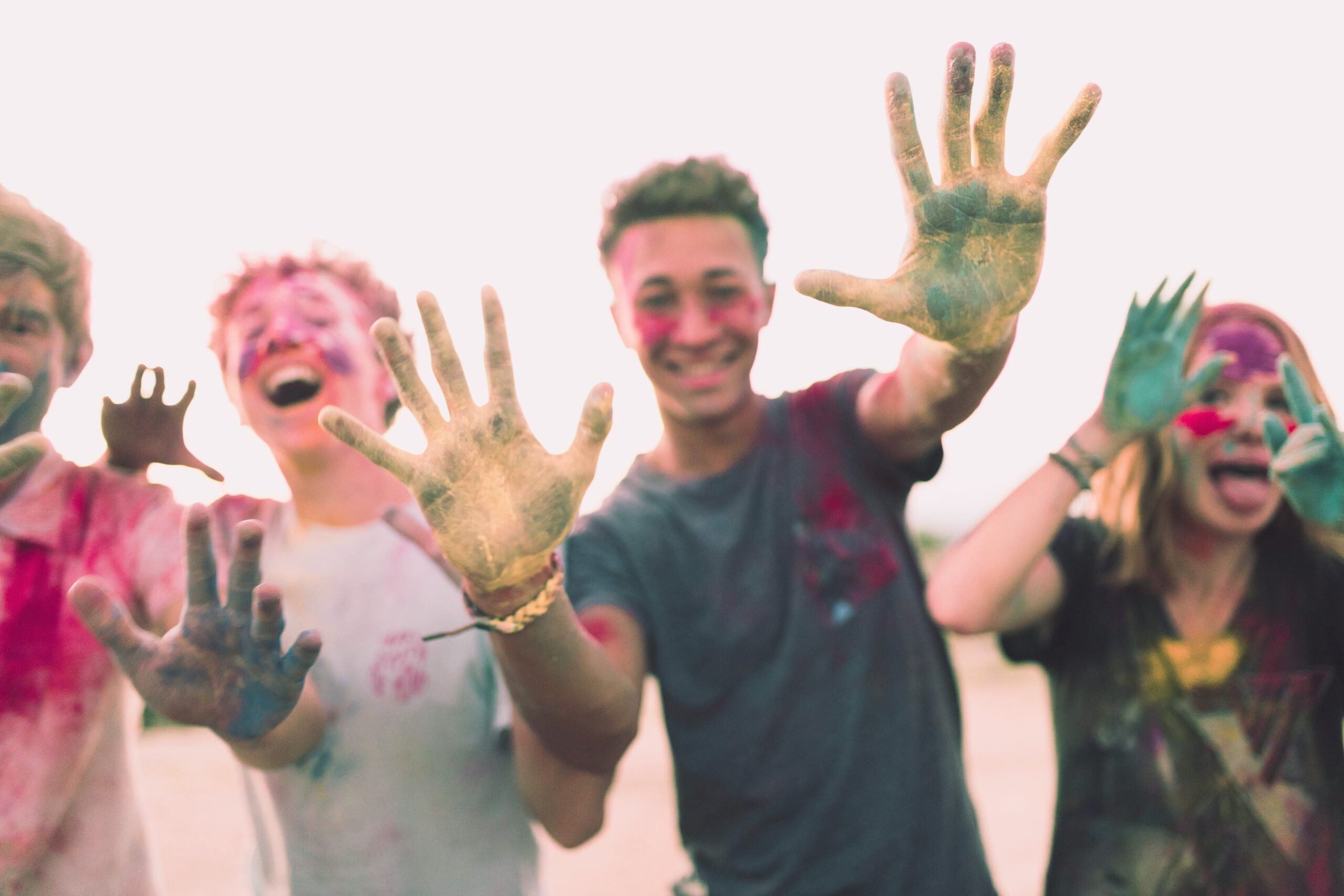 Teens smile with colored powder on hands 