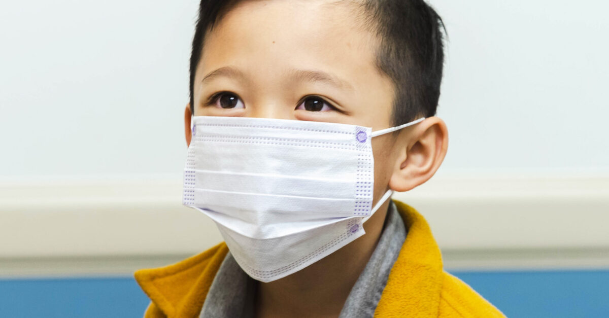 Child looks up while wearing mask at the pediatrician's office