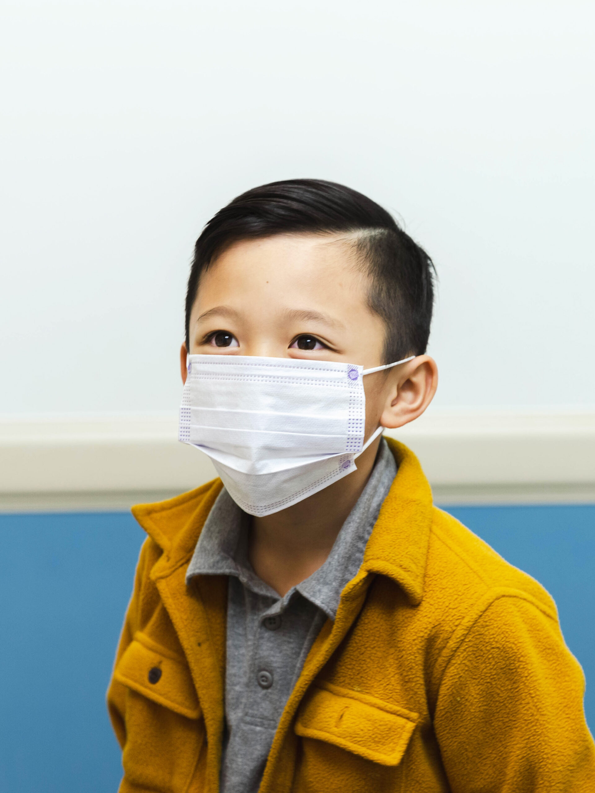Child looks up while wearing mask at the pediatrician's office