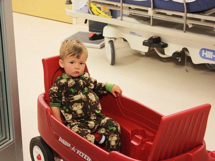 Baby Hudson in red wagon at the hospital 