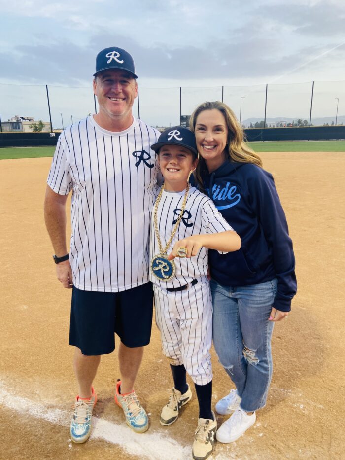 Garrison with his parents, Brooke and Ryan, on the baseball field. 