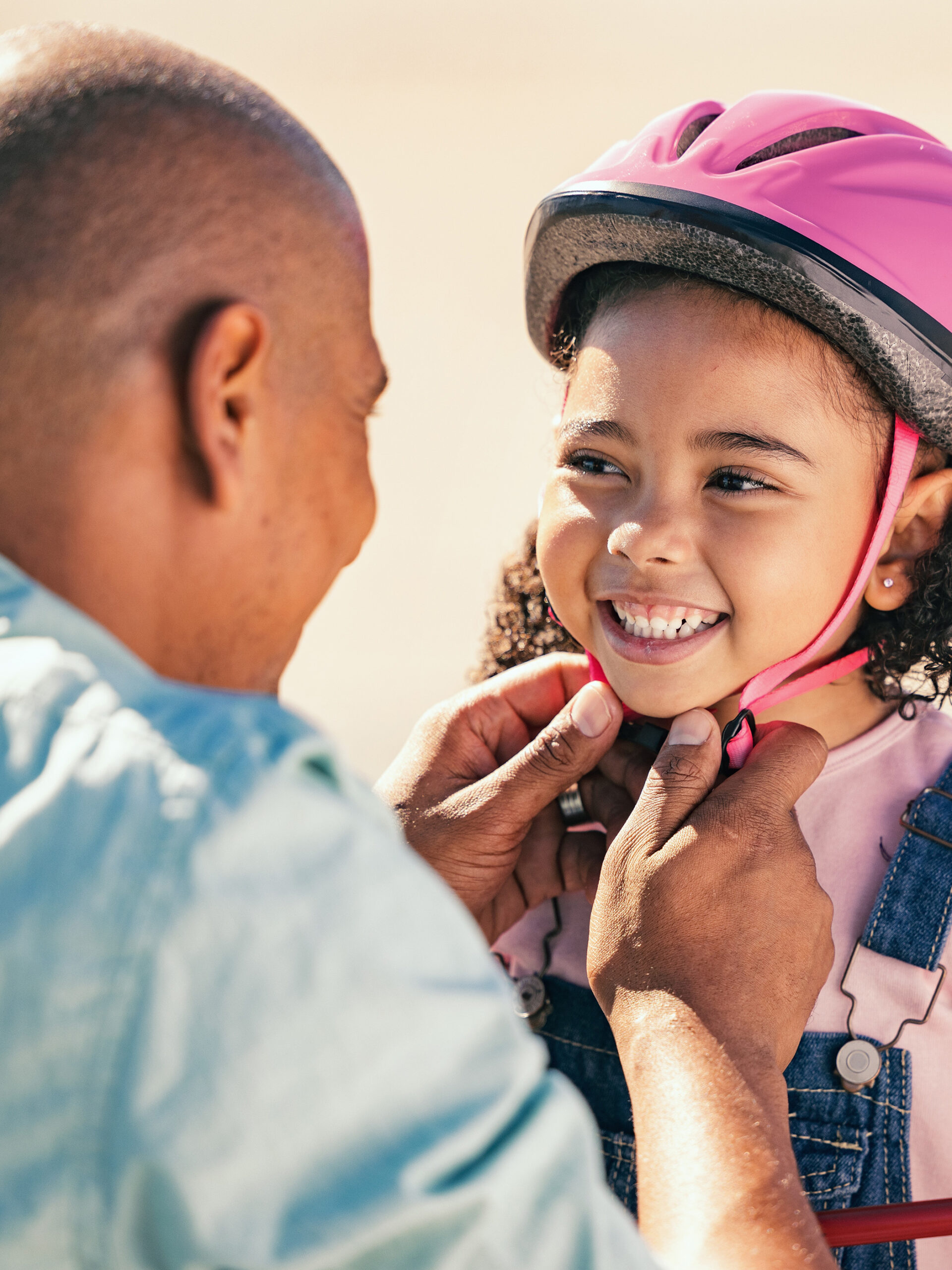 Parent helping child put on helmet - safety activities for kids
