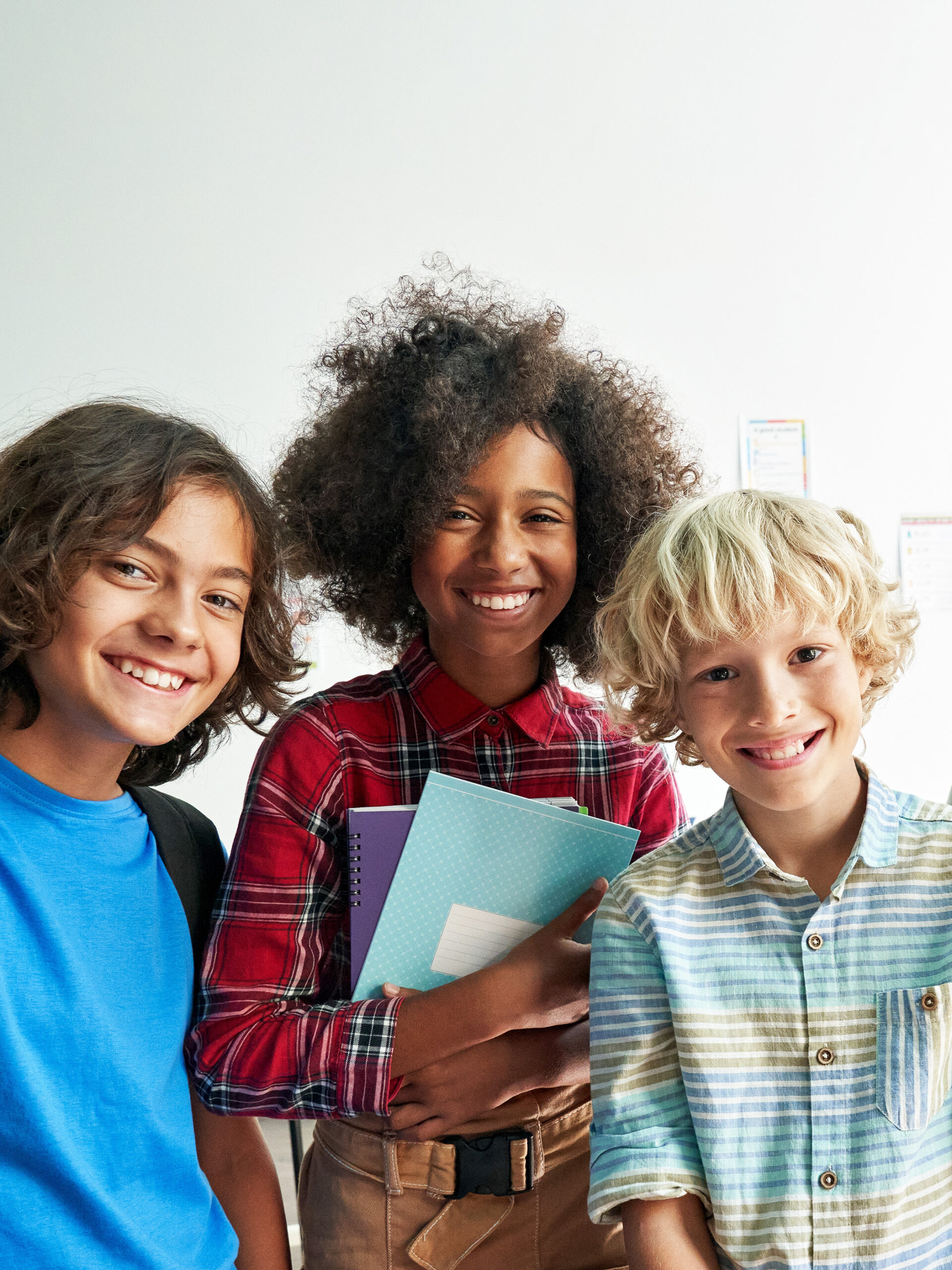 Three preteens smile together while at school - CHOC's tips for preteens and teens going through puberty