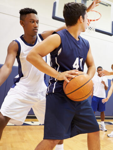 Teen boys play basketball during a game