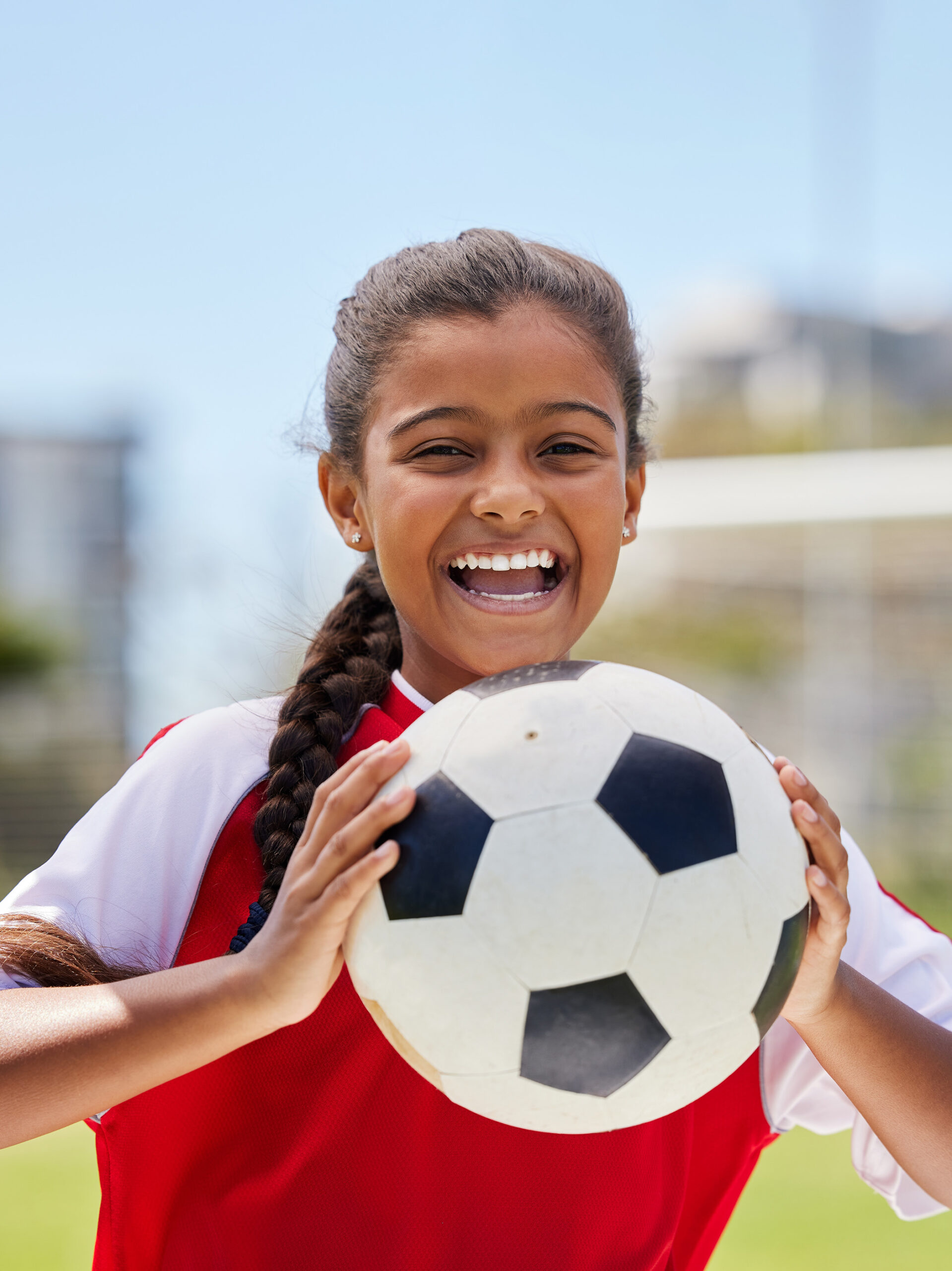 Girl smiles holding soccer ball
