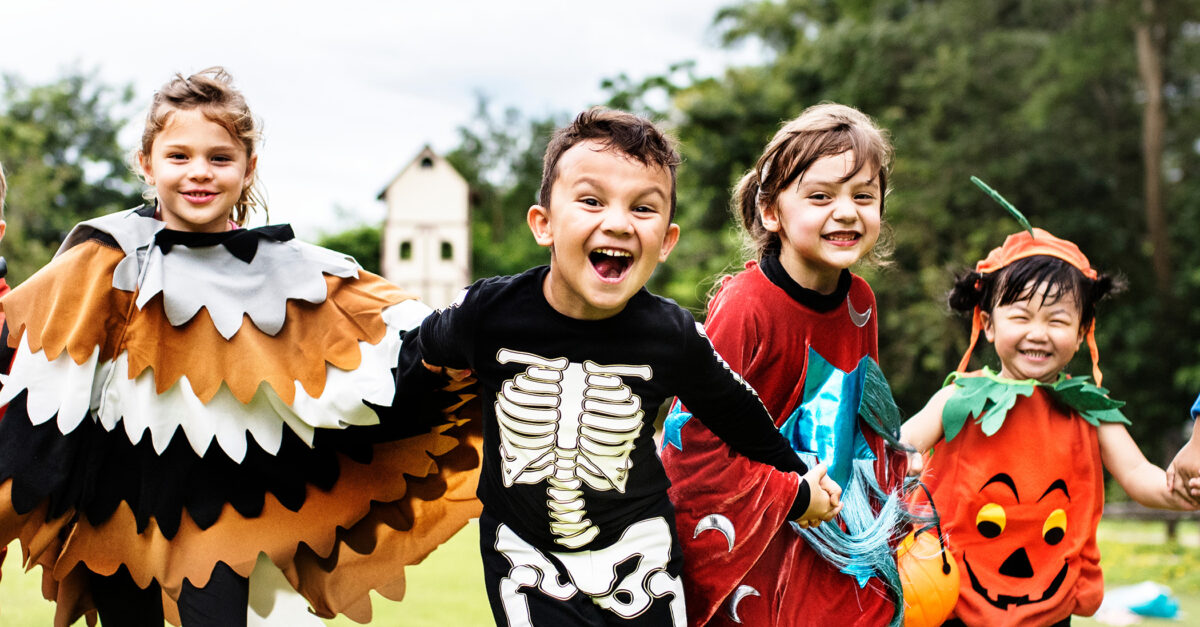 Kids wearing Halloween costumes run toward the camera