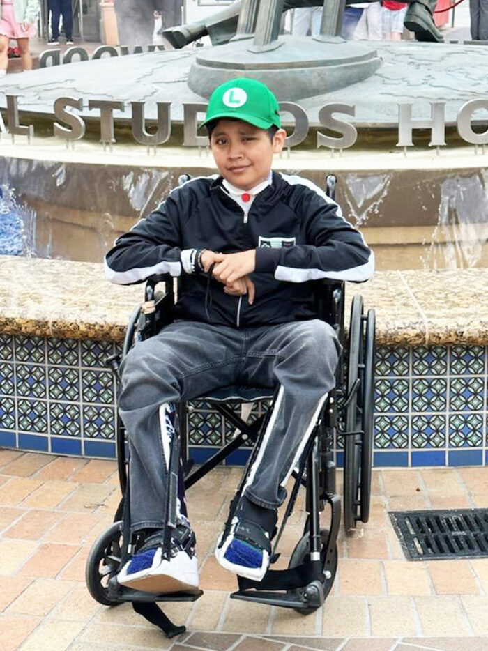 Kenny smiles in wheelchair at Universal Studios Hollywood