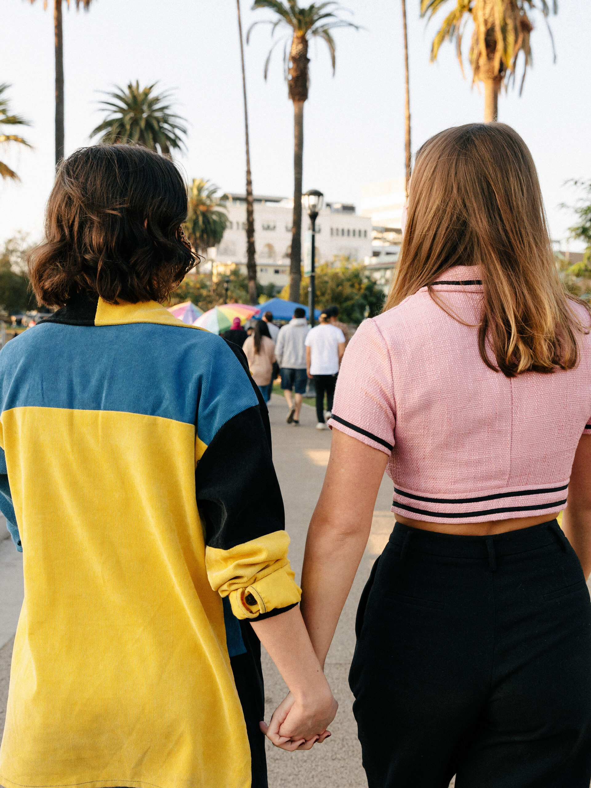 the backs of two young women holding hands