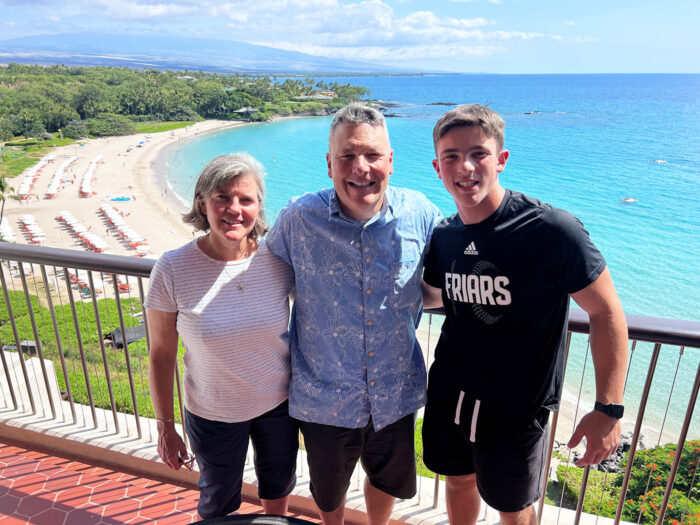 John with parents smiling in front of ocean in Hawaii
