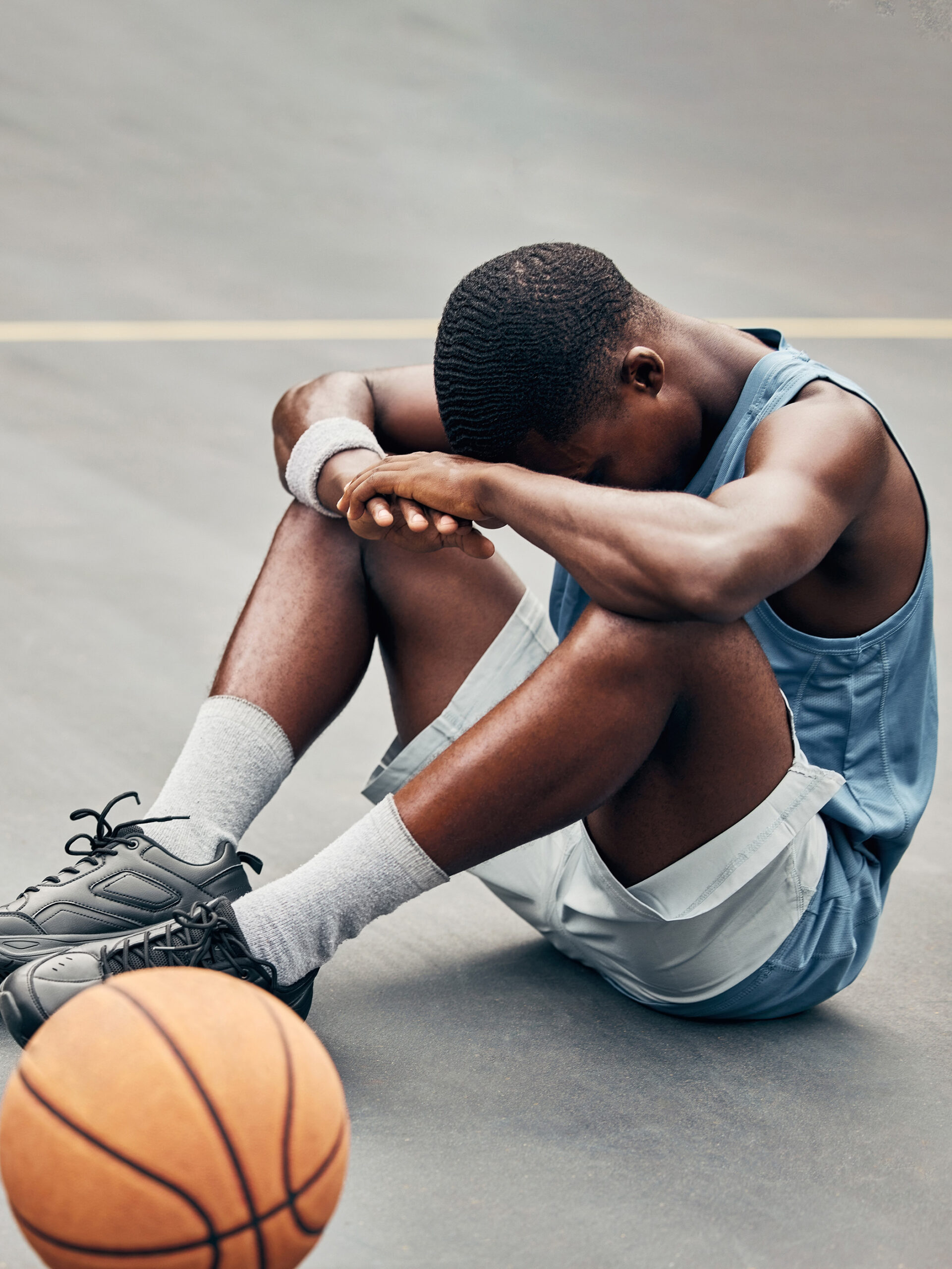 Young athlete puts head in hands while playing basketball - Tips for preventing athlete burnout from a CHOC Sports Medicine Physician
