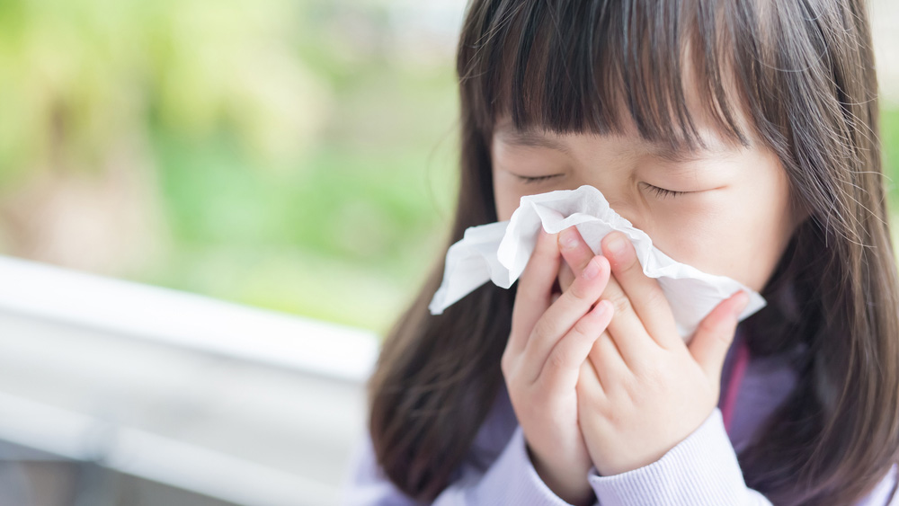 Child blows nose from respiratory illness